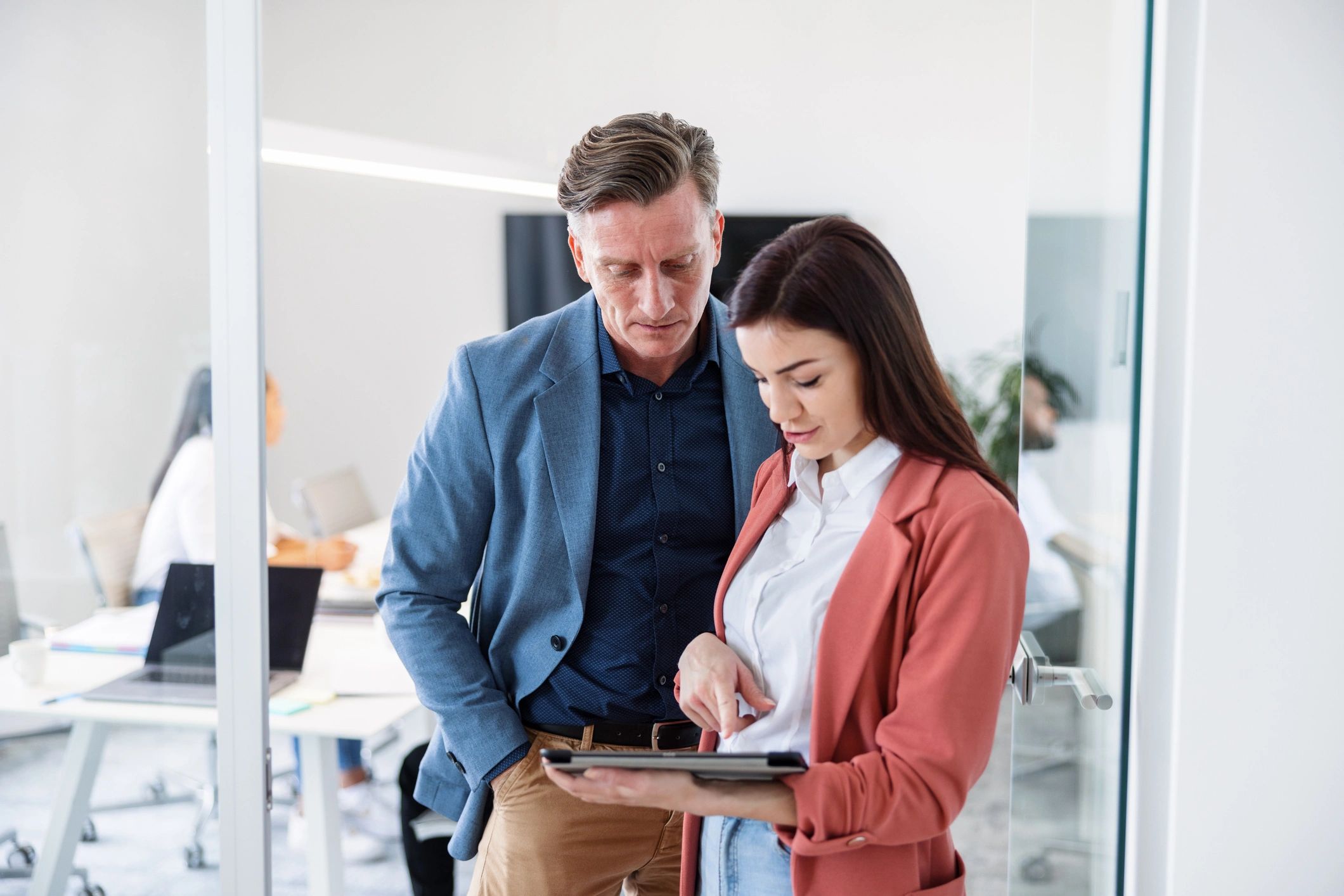 Two real estate professionals reviewing identity information together in an office